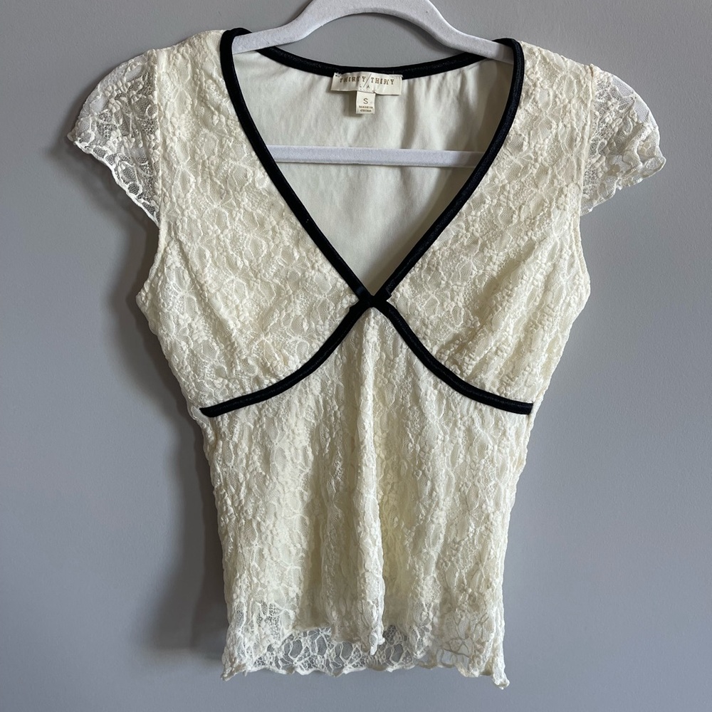 Cream lace V-neck top with black trim and bow